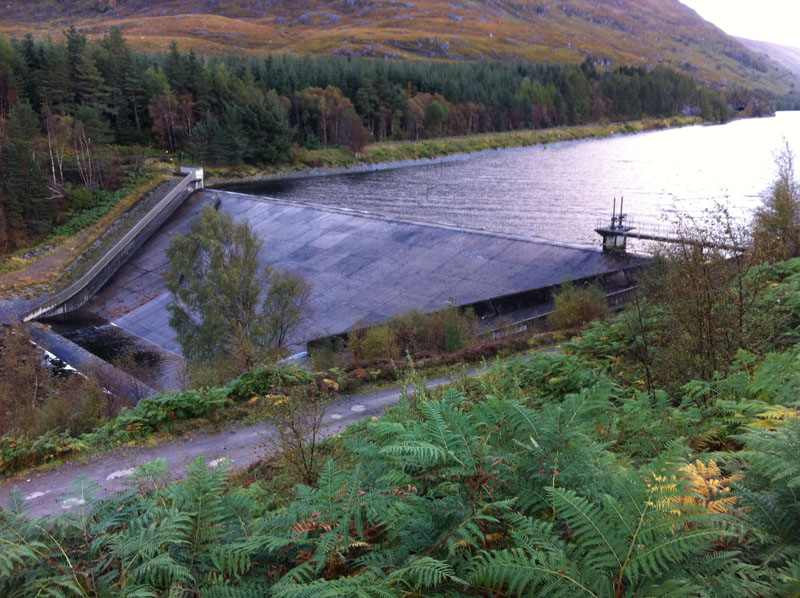 The resevoir so full its spilling over the top of the dam
